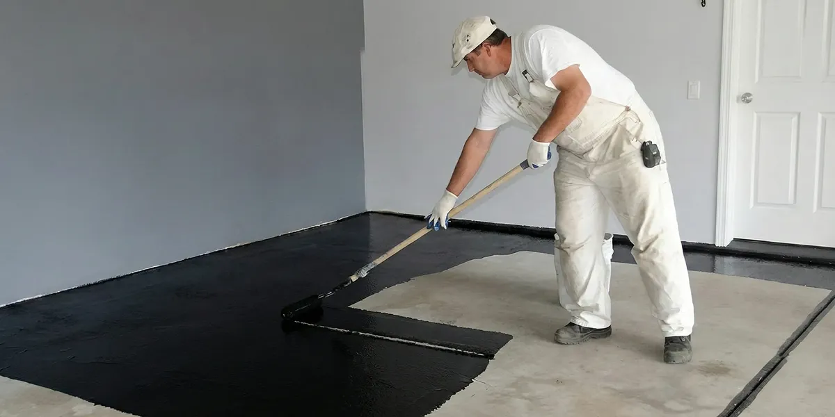 basement waterproofing professional applying waterproof coating to protect a basement floor in Lakeland, FL